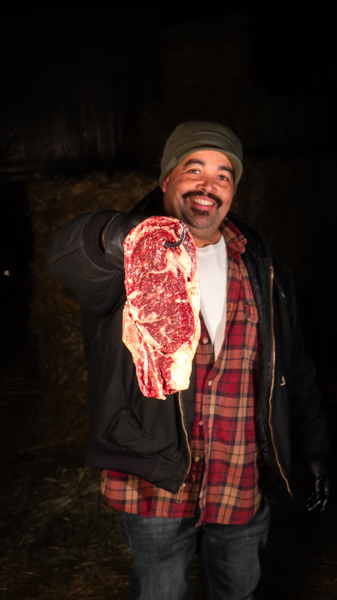 Ed holding up a dry-aged steak on the farm