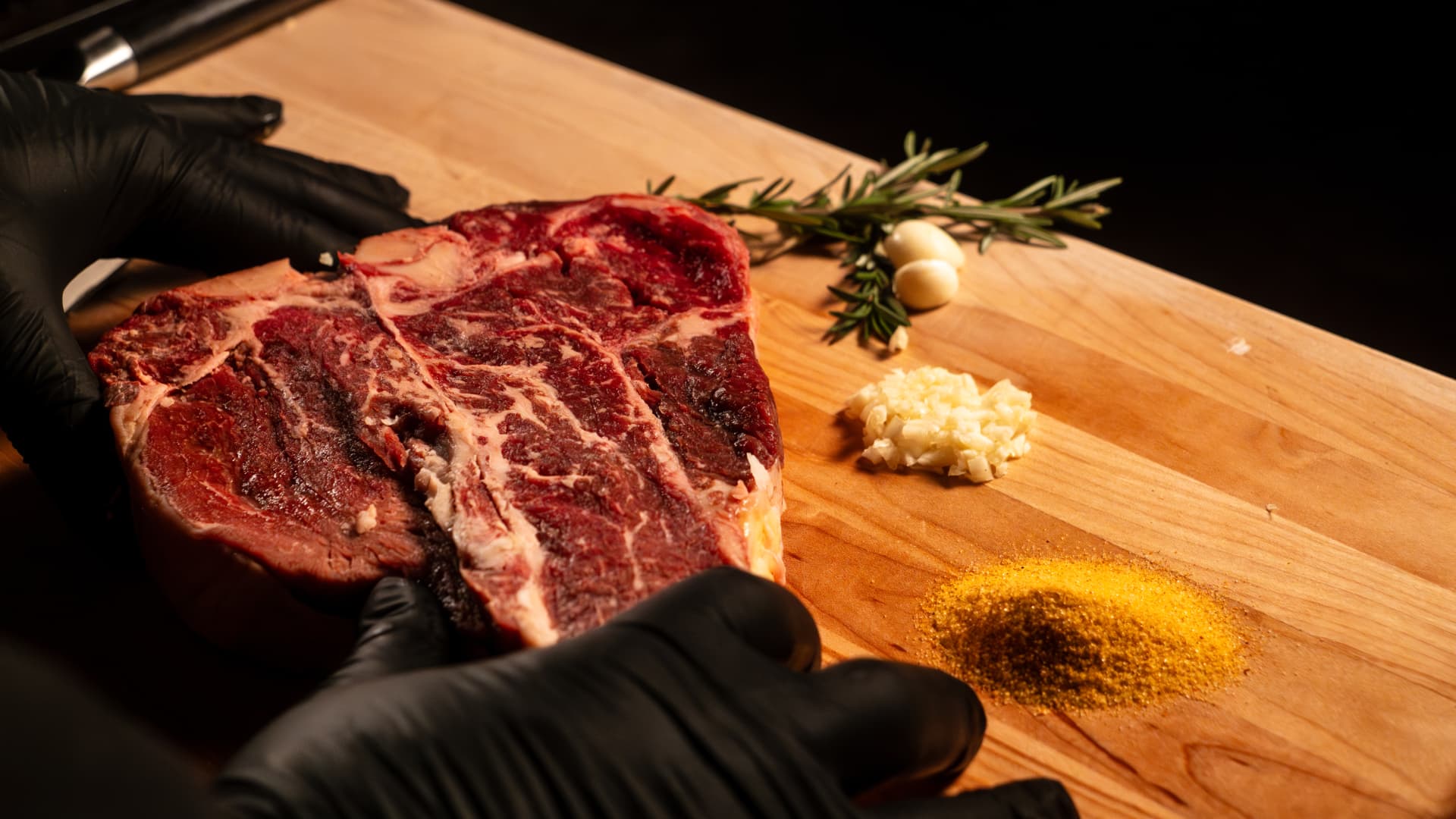A dry-aged porterhouse on a maple cutting board