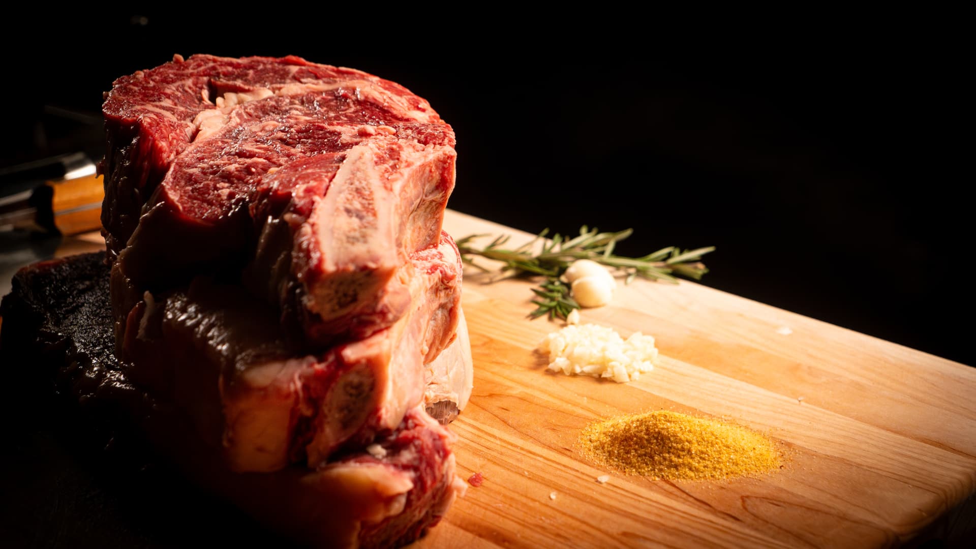 A stack of bone-in ribeye steaks